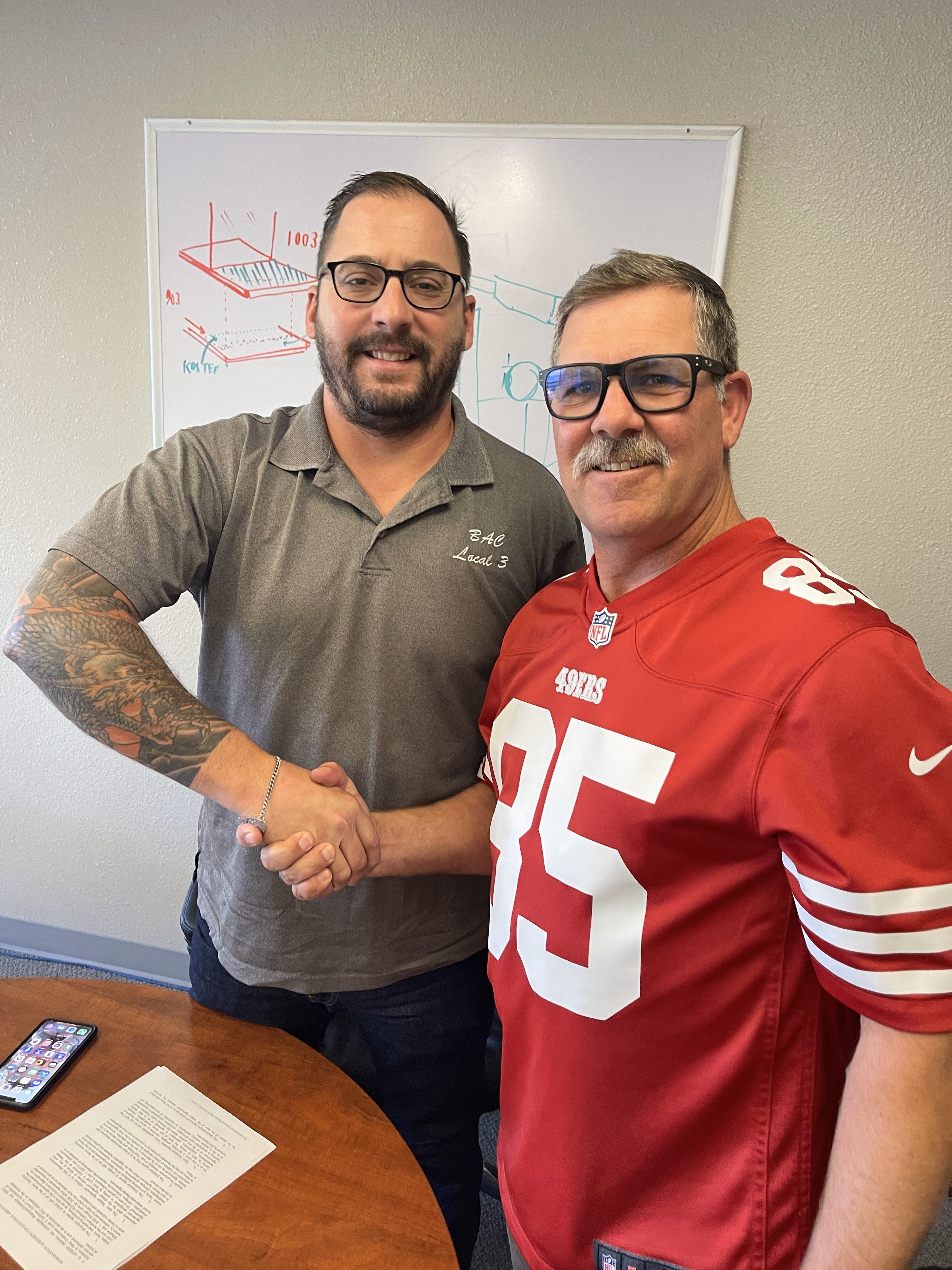 Urban Waterproofing partner Marshall Johnson and  Local 3 California Vice Chair Colin Johnson (no relation)  shake hands after signing Urban’s first BAC CBA.