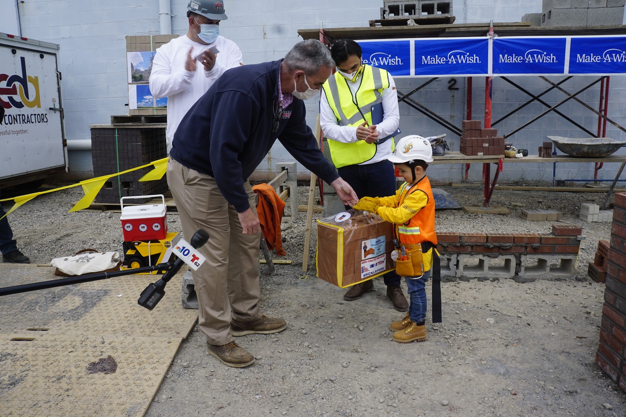 BAC International Field Representative Matthew Stafford presents a bag of toy bricks to Nicholas Esposito.